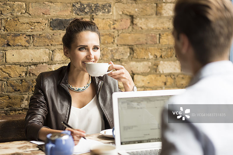 在咖啡馆喝茶的年轻男女商人图片素材