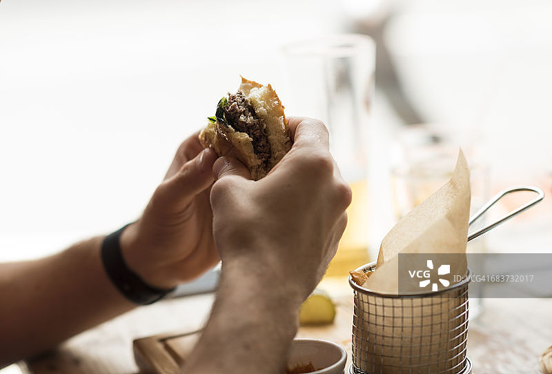 男子在餐厅吃汉堡图片素材