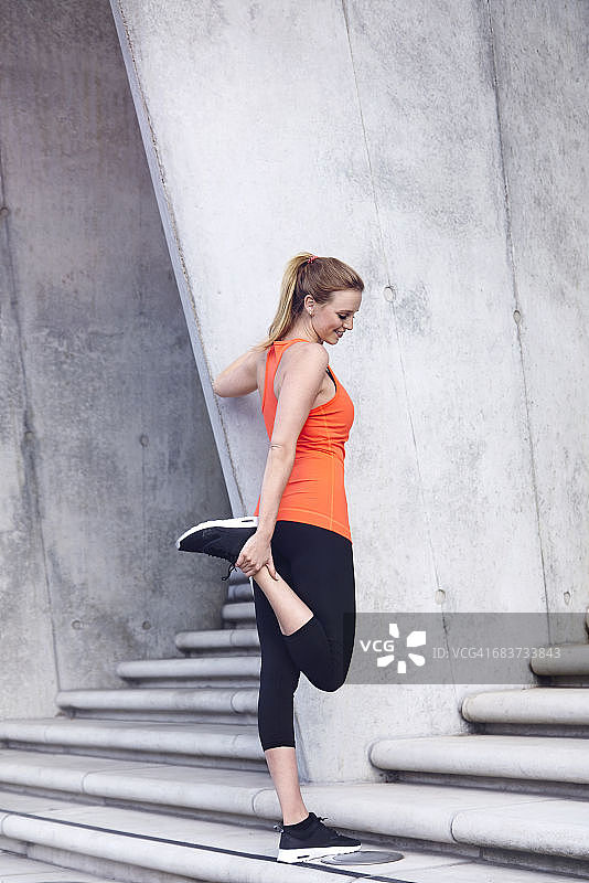 在台阶上拉伸脚踝的女人图片素材