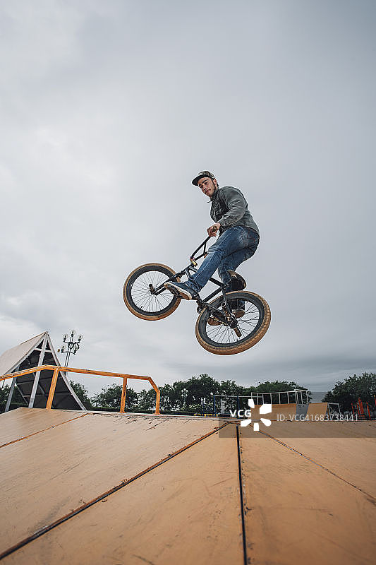 在滑板公园的自行车上表演特技的青少年图片素材