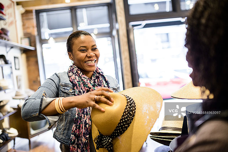 女人在帽子店试戴帽子图片素材