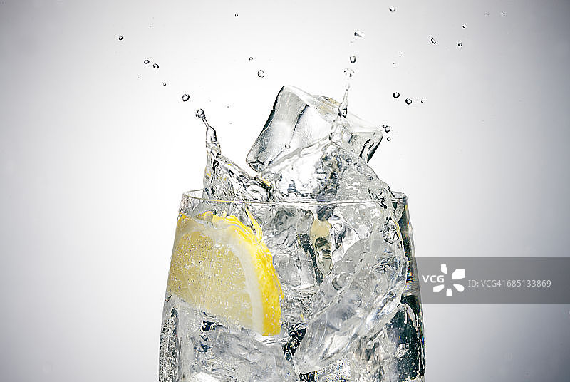 冰块溅入柠檬玻璃杯的特写图片素材