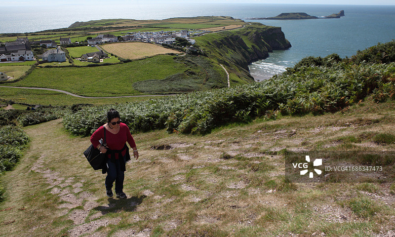 上坡行走，身后是美丽的风景图片素材