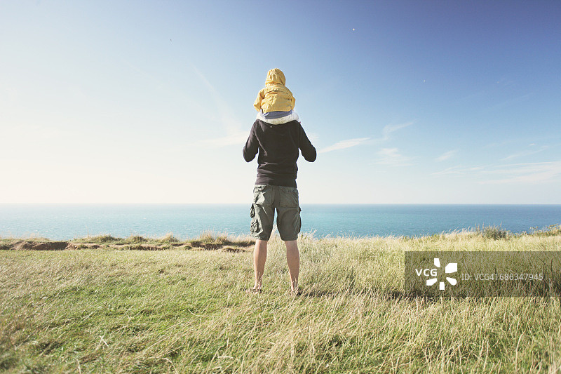 父亲在海边背着孩子图片素材