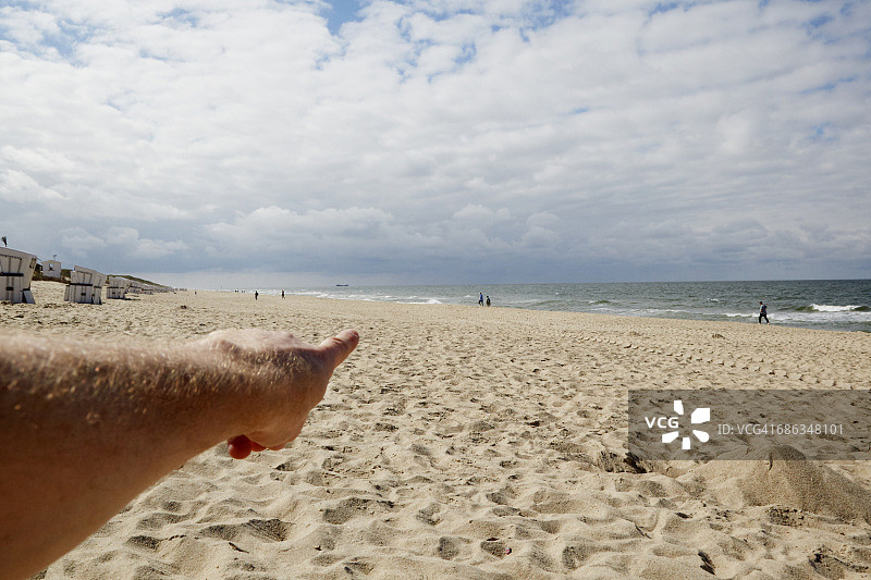 手指指向海滩图片素材