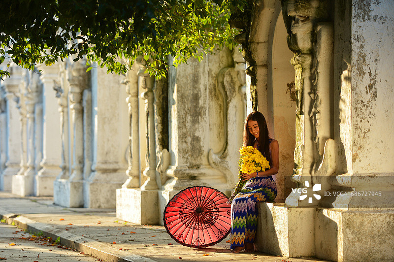 年轻女子坐在缅甸曼德勒寺庙外图片素材