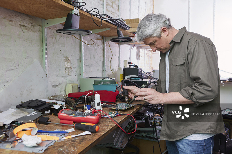 电脑回收厂工人焊接主板图片素材