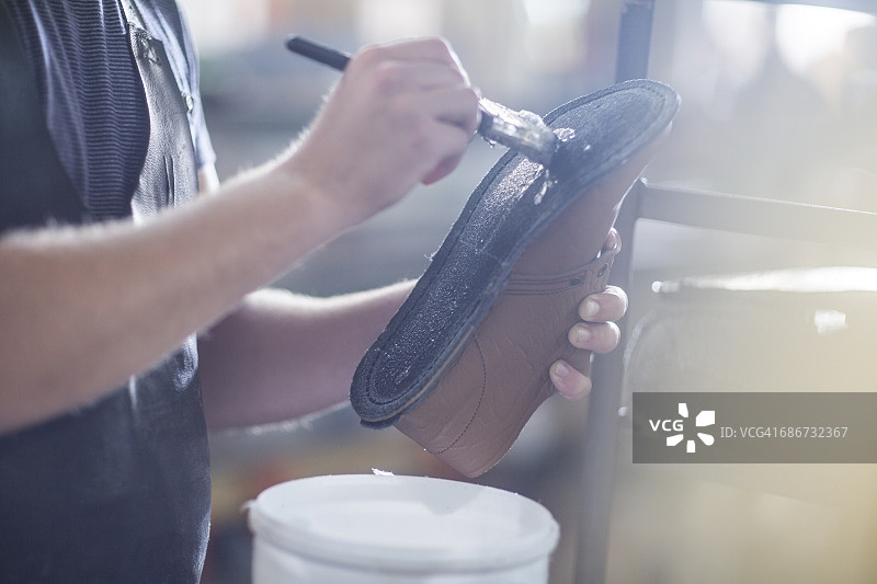 鞋匠在鞋底上涂胶水图片素材
