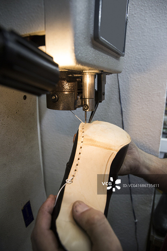 鞋匠在工作室用机器缝制鞋底图片素材