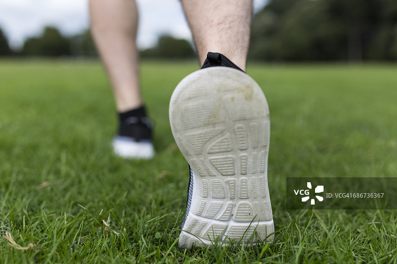 运动员在草地上跑步的鞋子图片素材