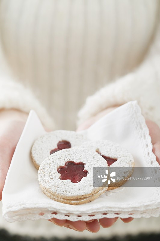 女人拿着放在餐巾上的果酱饼干图片素材