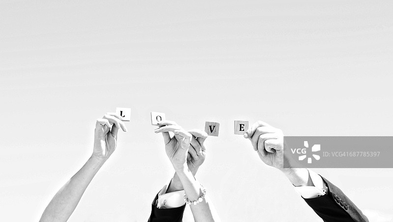 新娘和新郎举起拼写着“爱”的字母图片素材