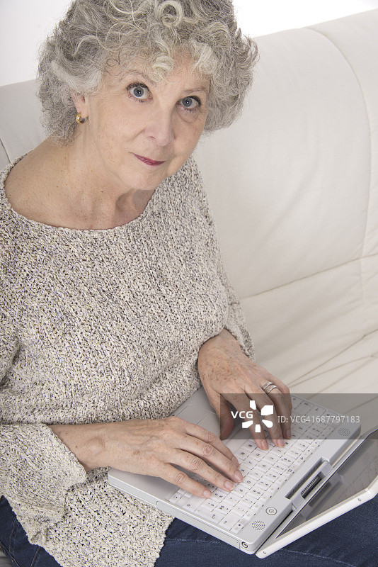 女人使用笔记本电脑看着镜头图片素材