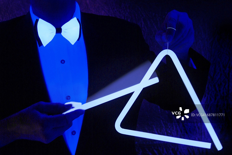 身着正装的男子敲击着发光三角形图片素材