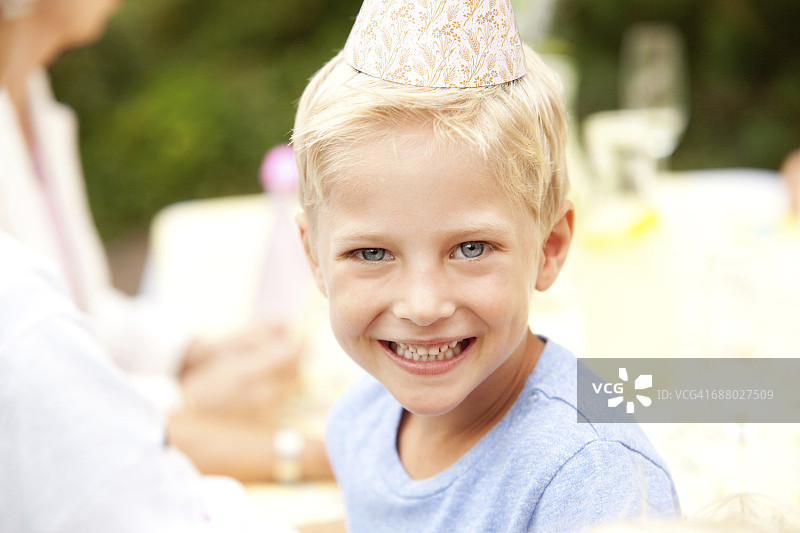 生日聚会上戴派对帽的金发男孩图片素材