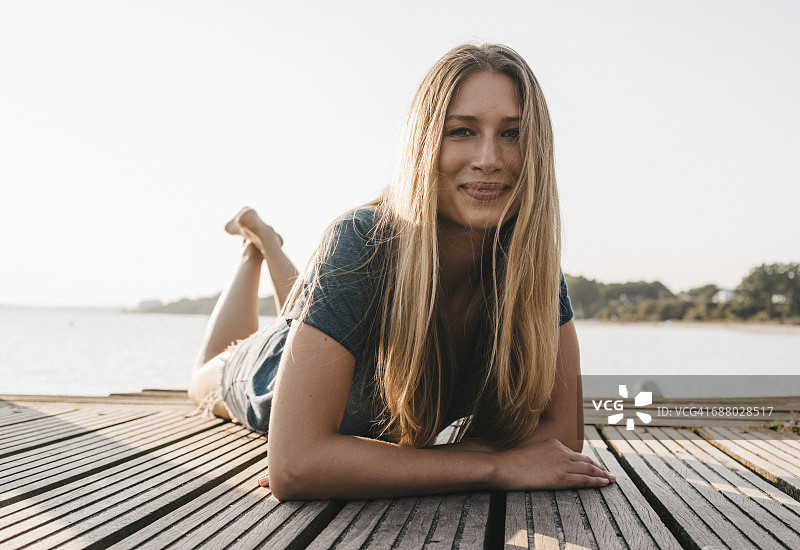 年轻女子躺在码头上图片素材