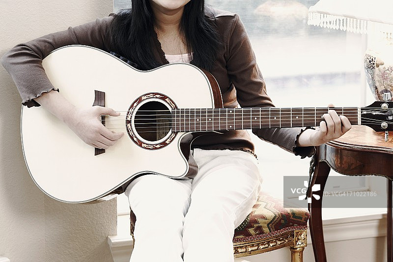 女孩弹吉他的身体中部视角图片素材