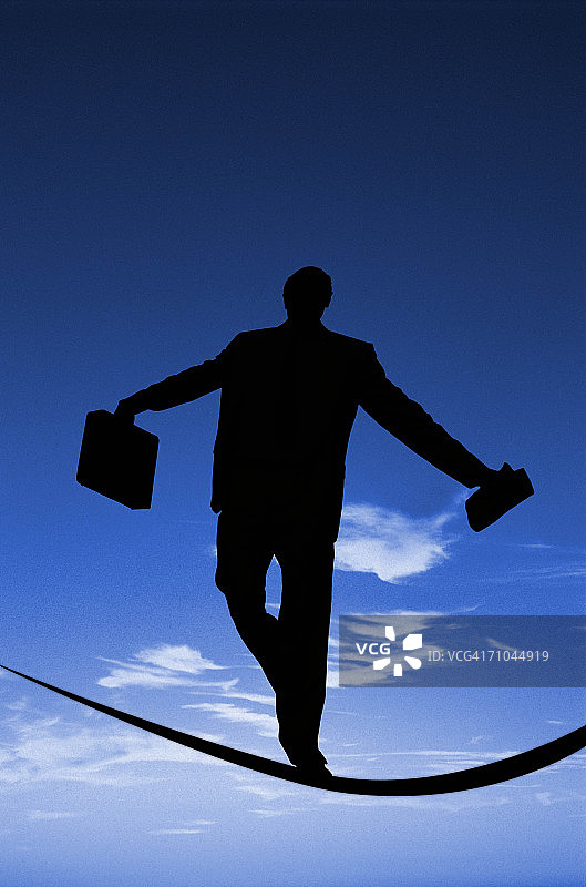 商人手提公文包走在钢丝上（背影）图片素材