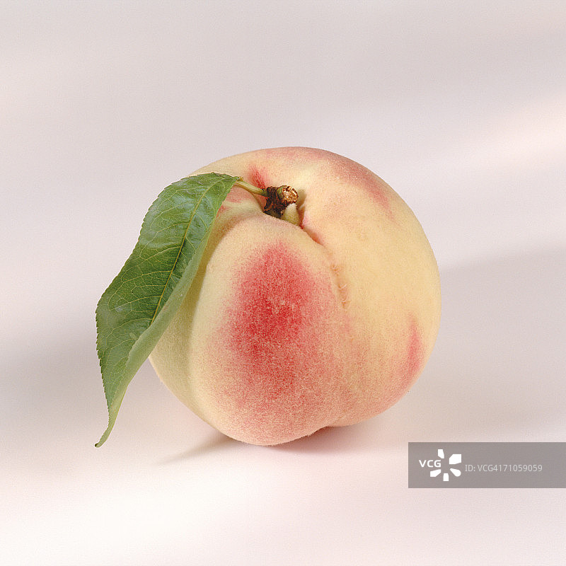 白色背景上的桃子和叶子特写图片素材