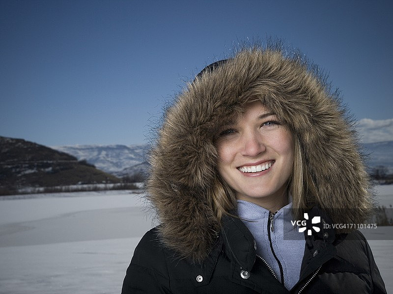 年轻女子身穿带毛皮帽子的夹克图片素材