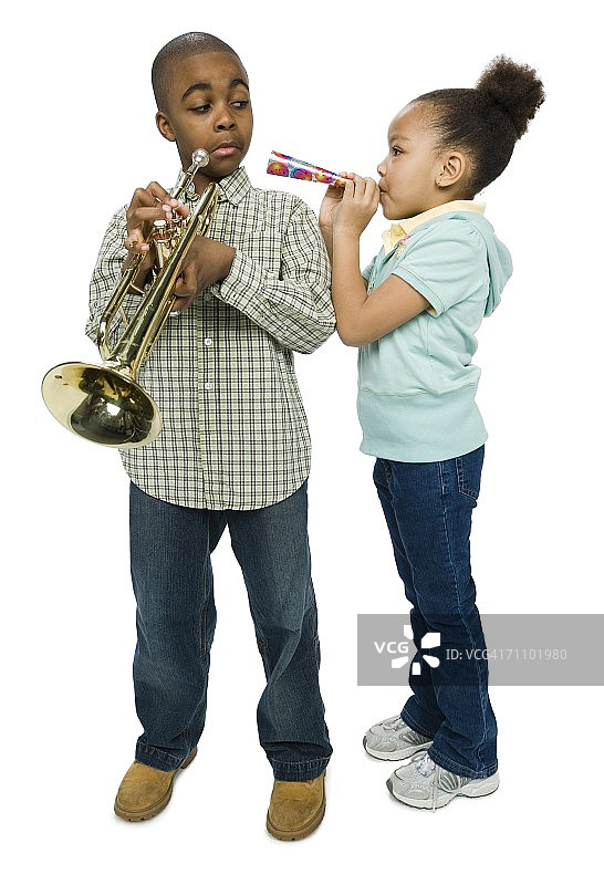 男孩看着姐姐吹派对喇叭图片素材