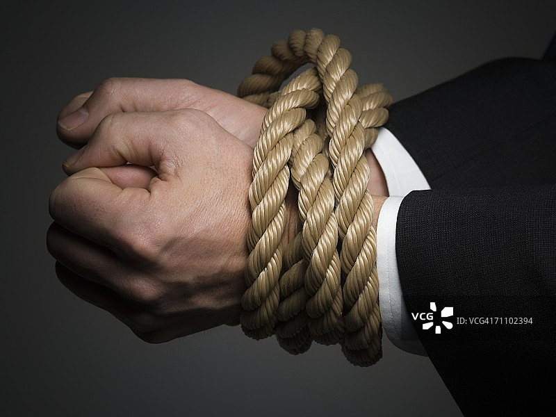 特写：男人双手被绳子捆绑图片素材