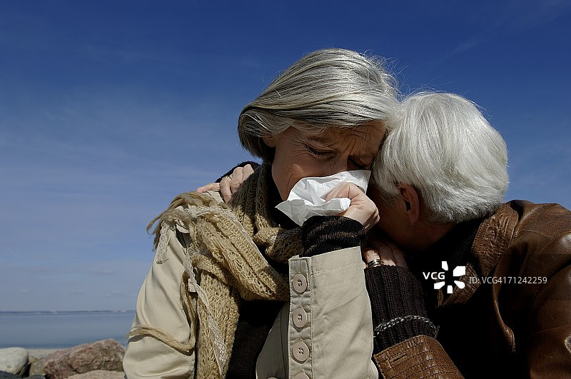 两位中年妇女互相拥抱，其中一位在哭泣图片素材