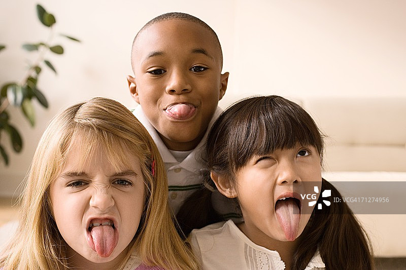 男孩和两个女孩在客厅里做鬼脸图片素材