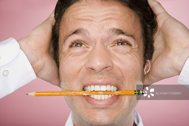 双手抱头的年轻男人特写图片素材