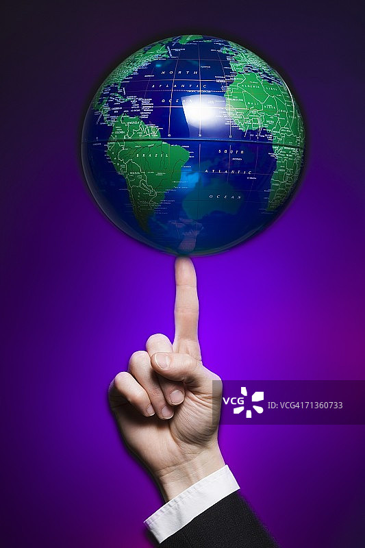 用手指旋转地球仪的人的手部特写图片素材