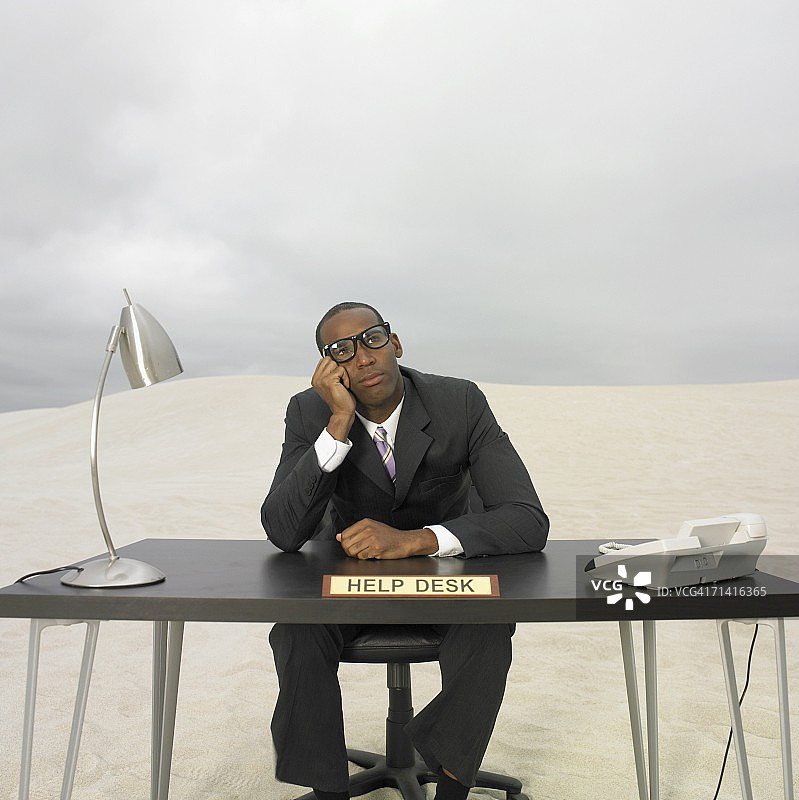 坐在沙漠服务台的非洲商人图片素材