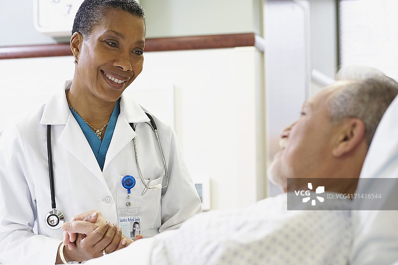 非洲女医生在医院病床旁为病人看诊图片素材