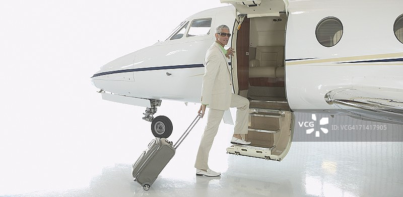 在机库里登上飞机的中年男人图片素材