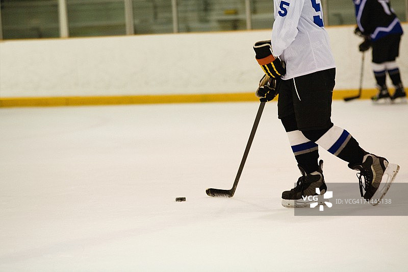 打冰球的冰球运动员侧面照图片素材