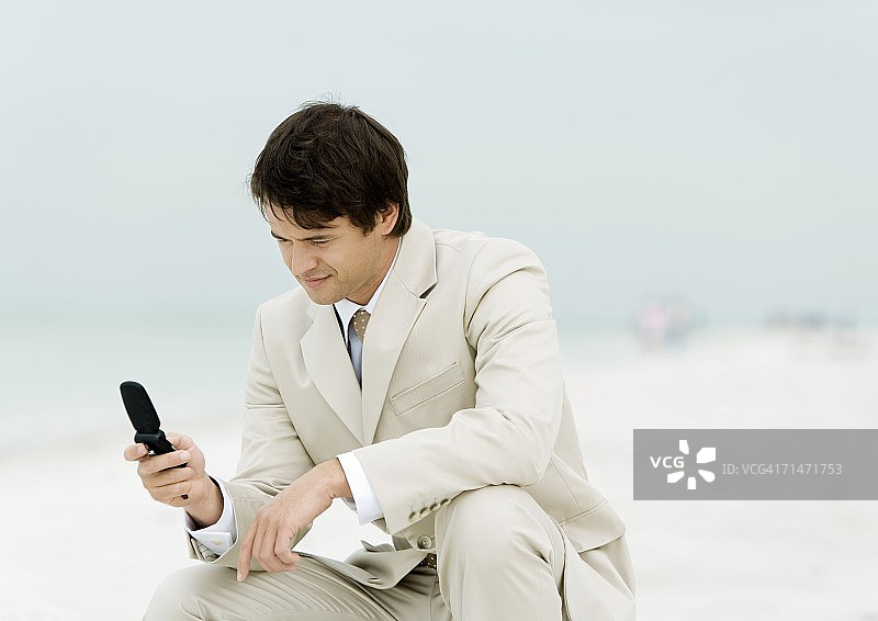 在海滩上使用手机的商人图片素材