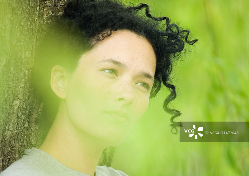 女人倚靠在树干上图片素材