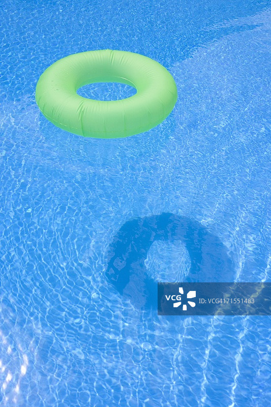 漂浮在游泳池中的充气游泳圈图片素材