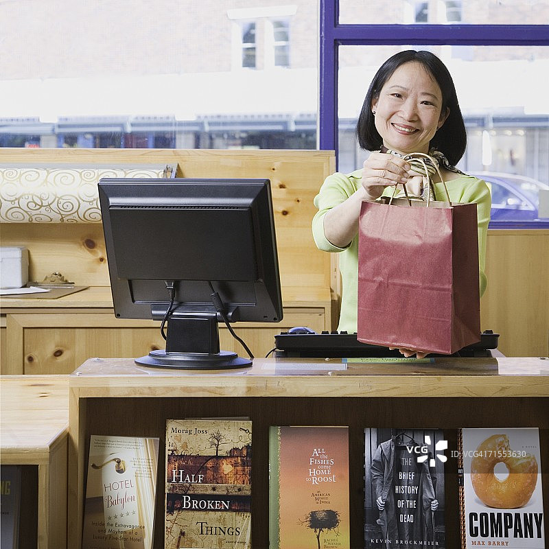 在书店工作的亚洲女销售员图片素材