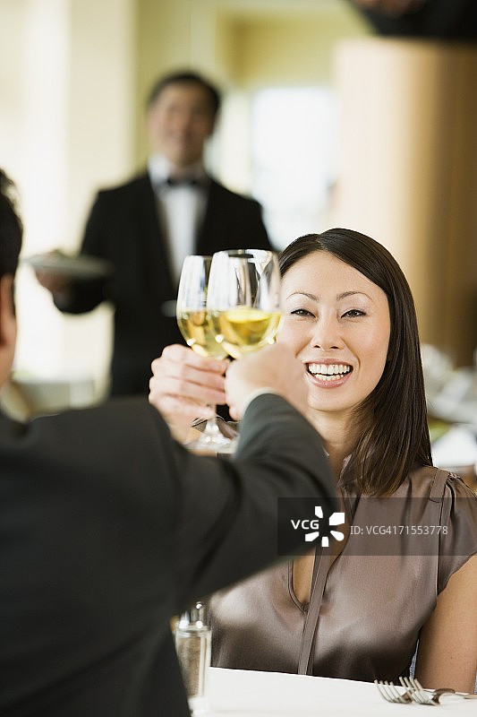 在餐厅敬酒的亚洲女人图片素材
