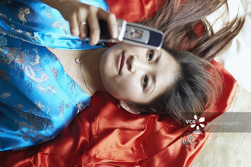 手持手机的年轻女子的俯视角度照片图片素材