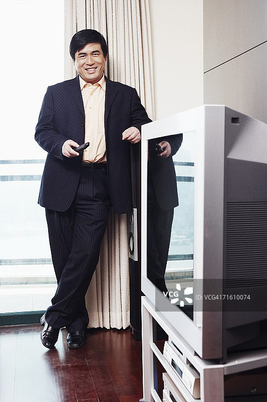 手持遥控器微笑的商人肖像图片素材