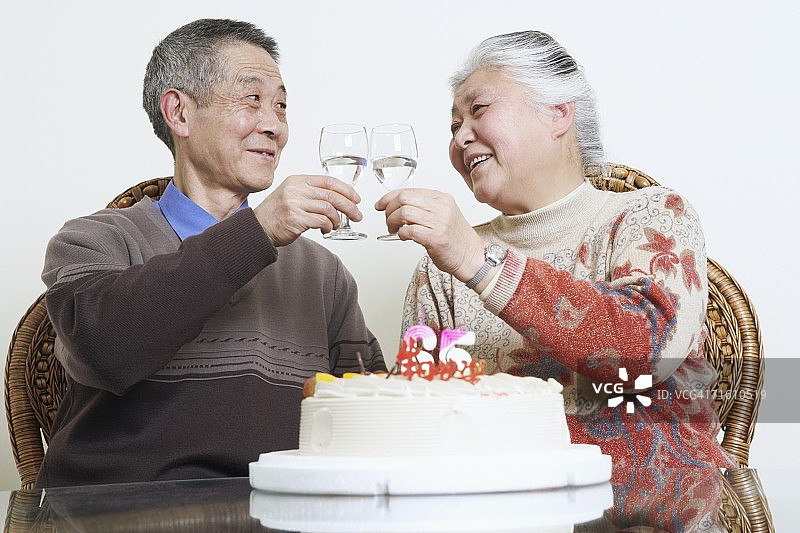 一对老年夫妇用酒杯敬酒的特写图片素材