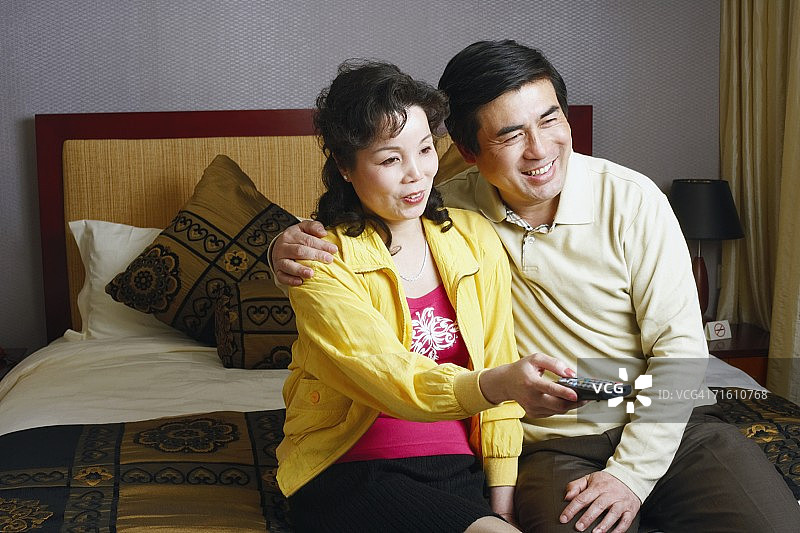 两位中年妇女坐在一起，一位拿着遥控器图片素材