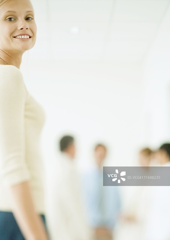 年轻女商人，同事站在背景中图片素材