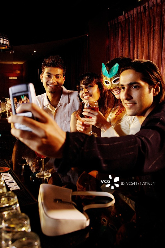 在酒吧用手机拍照的情侣图片素材