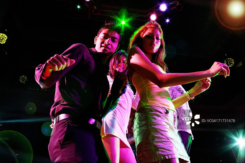 在俱乐部跳舞并看向镜头的情侣图片素材