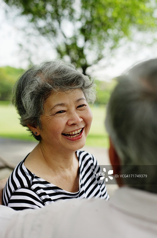 中年夫妇面对面，女士穿着条纹衬衫，面带微笑图片素材