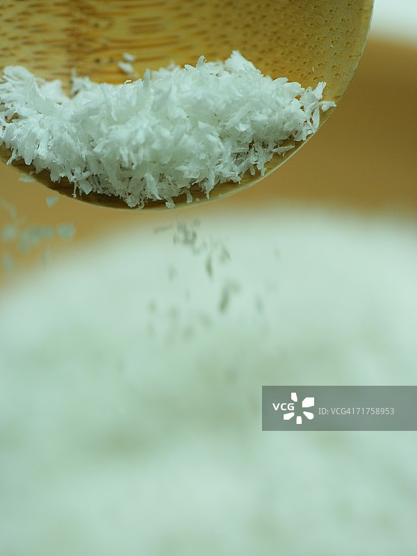 木勺将椰奶粉倒入碗中的特写图片素材