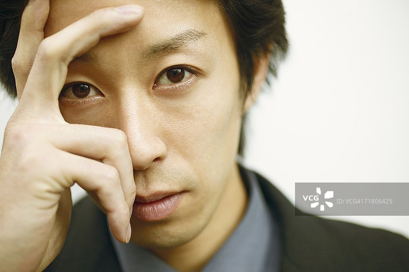 手扶头部的年轻男子肖像图片素材