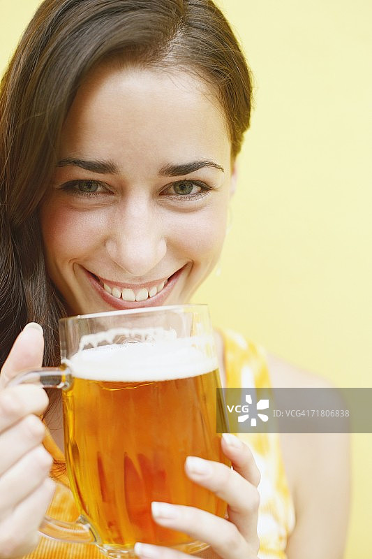 年轻女子拿着一杯啤酒的画像图片素材